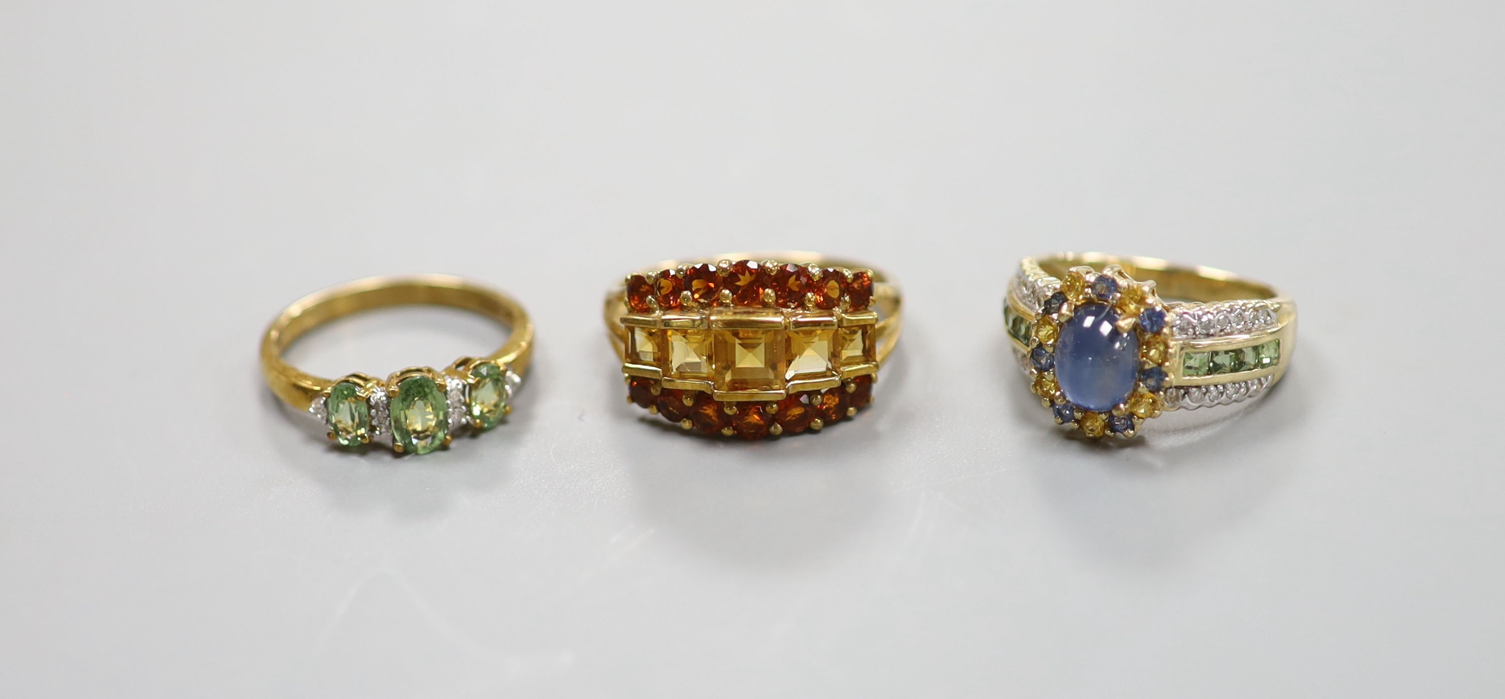 A 9ct gold cabochon sapphire and diamond ring and two other 9ct gold gem-set rings